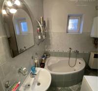 Bathroom in a family house with a bathtub, sink, and window.