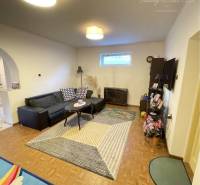 Living room with a sofa and television in a family house with a wooden decor floor.