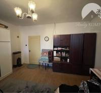 A room in a family house with a wooden decor floor, cabinets, and chandeliers.