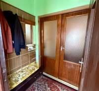 Entrance hall in a family house with coat racks and wooden doors, carpet on the floor.