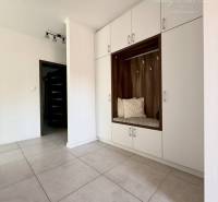 Interior of a family house with light tiles and built-in wardrobes.