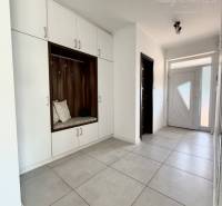 The entrance hall of a family house with white built-in wardrobes and tiles.