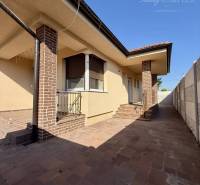 A family house in Okoč with brick details and a paved courtyard.