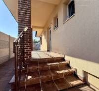 Entrance to a family house in Okoč with brick walls and tiles on the stairs.