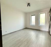 Interior of a family house with a wooden decor floor and two windows.