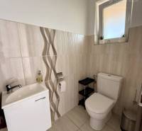 A bathroom in a family house with ceramic tiles and a modern sink.