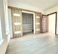 A room with doors featuring glass elements and a floor with a wooden decor in a family house.