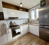 Kitchen in a 4-room apartment with wooden flooring, white cabinets, and stainless steel appliance.