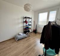 A room with white walls and a wooden floor in a 4-room apartment.