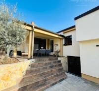 A family house with a terrace, stairs, and a stone-clad wall, ideal for a peaceful life.