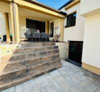 Family house with a terrace, garden furniture, and a paved staircase, ideal for outdoor relaxation.