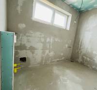 The interior construction in a 3-room apartment with an uncovered floor and a large window.