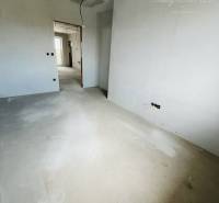 An empty room awaiting completion in a 3-room apartment with a wooden decor floor.