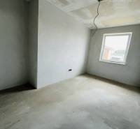 Unfurnished room in a 3-room apartment, simple walls, ceiling prepared for lighting.