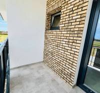 The balcony of a 3-room apartment in Veľký Meder with brick cladding and modern tiles.