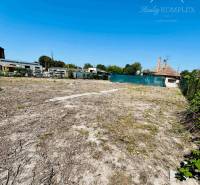 A plot for residential use in Veľký Meder with a view of the surrounding architecture.