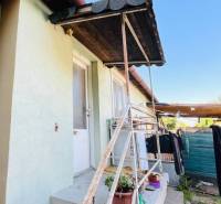 A family house in Okoč with an outdoor staircase and potted plants.