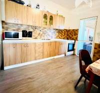 A kitchen in a family house with wooden decor and basic appliances.