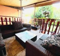 The terrace of a family house in Okoč with comfortable rattan furniture.