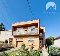 A family house in Okoč with a garden and a balcony under the blue sky.