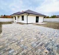 A family house in Topoľníky with a paved area and a roof with dark tiles.