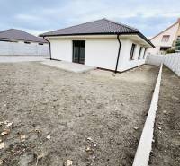 A family house in Topoľníky with a simple garden and a gray roof.