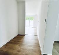 A hallway in a family house with a wooden decor floor and white walls.