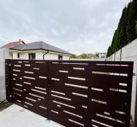 A gate in front of a family house in Topoľníky with a design of horizontal openings.