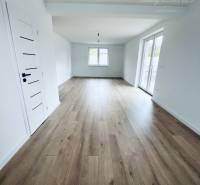 Interior of a family house with white walls and a wooden decor floor.