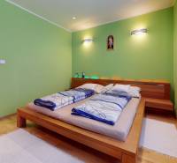 Bedroom in a 2-room apartment with a bed and wooden decor flooring.