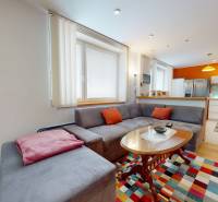 Living room in a two-room apartment with a kitchen and a wooden decor floor.