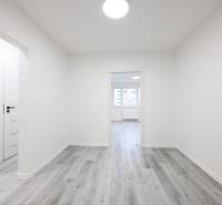 A bright hallway with wood-patterned flooring and white walls in a 3-room apartment.