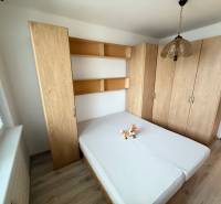 Bedroom with a bed and cabinets in a 2-room apartment, floor with wood decor.