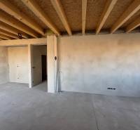 The interior of a family house with unfinished walls and a wooden ceiling in the process of renovation.