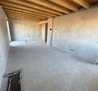 Interior of a family house with visible ceiling beams and concrete floor.