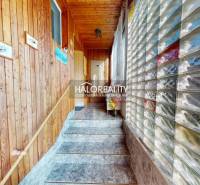 Interior of a family house with tiles, wooden paneling, and a glass wall.