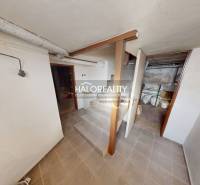 Basement of a family house with a classic staircase, rooms, and storage spaces, white walls.