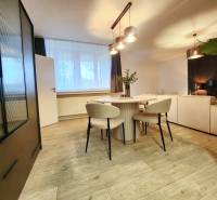 Dining area with a round table, chairs, and a wooden decor floor in a 2-room apartment.