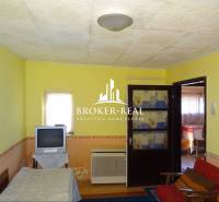 Living room in a family house with a television and double doors.