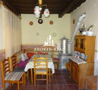 A rustic kitchen in a family house with tiles, wooden furniture, and ceramic decorations.