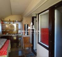 Interior of a family house with older furniture, a bed, and various decorations.