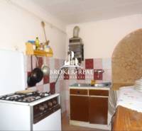 A kitchen in a family house with a gas stove and ceramic tiles on the wall.