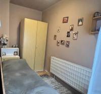 A room with a bed, wardrobe, and decorations, wooden floor decor, family house.