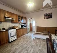 A kitchen in a family house with a wooden decor floor and wooden furniture.