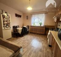 A kitchen in a family house with a wooden decor floor, a table, and a sofa set.