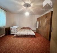 Children's room with carpeted floor, bed, light, and wardrobes in a family house.