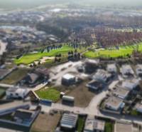 Aerial view of residential plots in Hrubá Borša with greenery and a golf course.