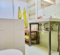A bathroom in a family house with a sink, towels, and a radiator on the walls.