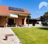 A family house in Komárno with a terrace, solar panels, and a swimming pool in the garden.