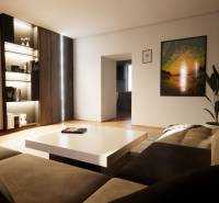 Living room in a family house with a sofa, a plant, wood-patterned flooring, and modern art.